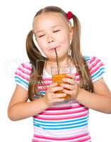 Little girl is drinking carrot juice