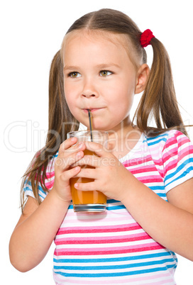 Little girl is drinking carrot juice