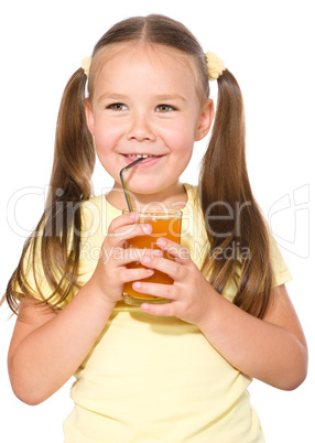 Little girl is drinking carrot juice