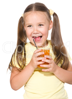 Little girl is drinking carrot juice