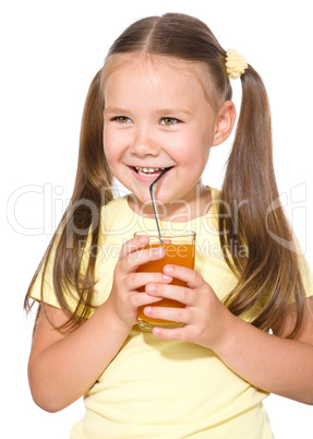 Little girl is drinking carrot juice