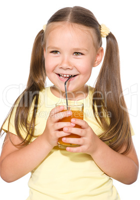 Little girl is drinking carrot juice