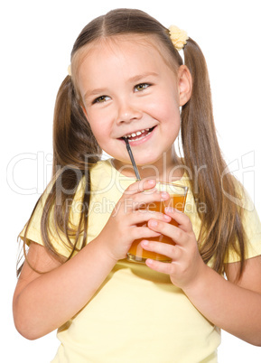 Little girl is drinking carrot juice