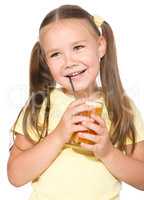 Little girl is drinking carrot juice