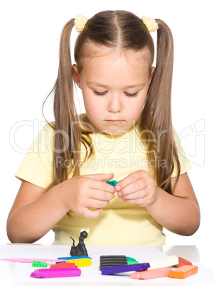 Little girl is playing with plasticine