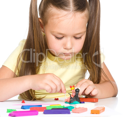 Little girl is playing with plasticine