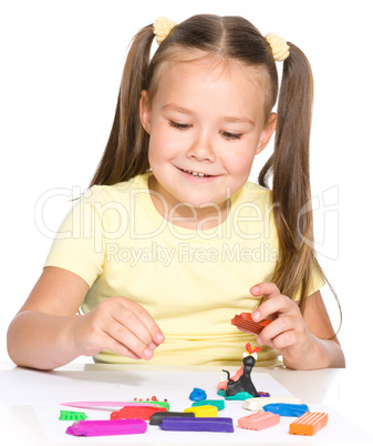 Little girl is playing with plasticine