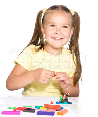 Little girl is playing with plasticine