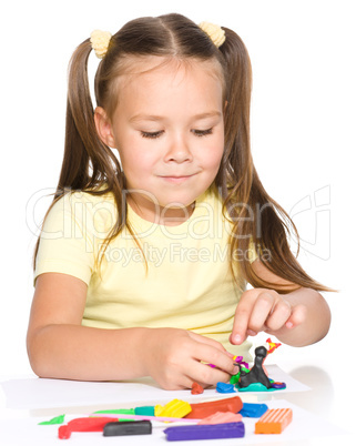 Little girl is playing with plasticine