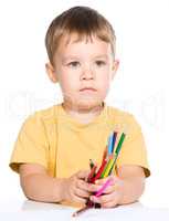 Little boy is holding color pencils