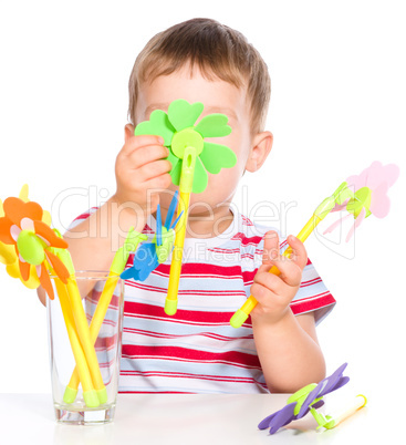 Boy is playing with artificial flowers toys
