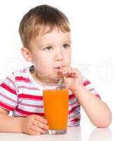 Little boy with glass of carrot juice