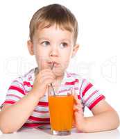 Little boy with glass of carrot juice