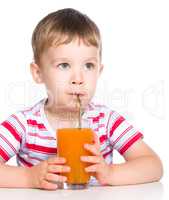 Little boy with glass of carrot juice