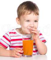 Little boy with glass of carrot juice