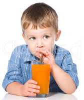 Little boy with glass of carrot juice