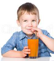 Little boy with glass of carrot juice