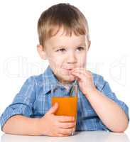 Little boy with glass of carrot juice