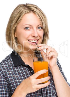 Young woman is drinking carrot juice