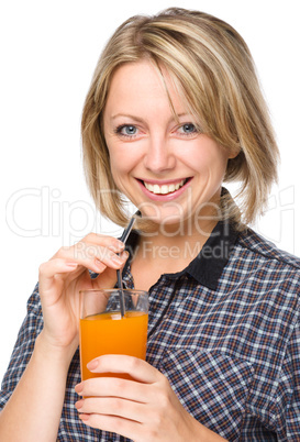 Young woman is drinking carrot juice