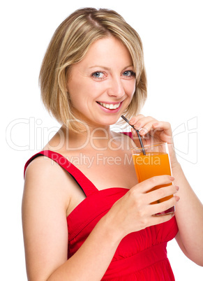 Young woman is drinking carrot juice