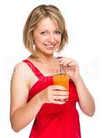 Young woman is drinking carrot juice