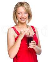 Young woman is drinking cherry juice