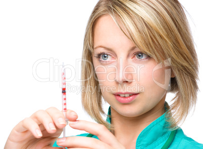 Young nurse is preparing syringe for injection