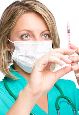 Young nurse is preparing syringe for injection