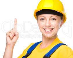 Young construction worker pointing up