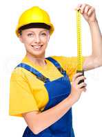 Young construction worker with tape measure