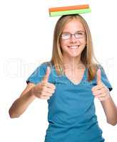 Young student girl is showing thumb up gesture