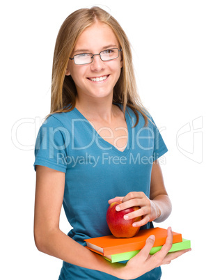 Young student girl is holding book and apple
