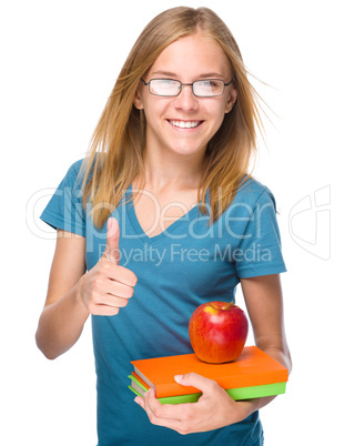 Young student girl is holding book and apple