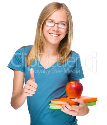 Young student girl is holding book and apple