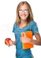 Young student girl is holding book and apple
