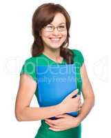 Young skinny student girl is holding exercise book