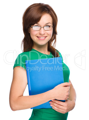 Young skinny student girl is holding exercise book