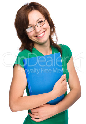 Young skinny student girl is holding exercise book