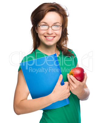 Young student girl is holding book and apple