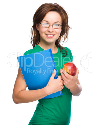 Young student girl is holding book and apple