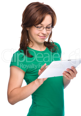 Young cheerful woman is using tablet