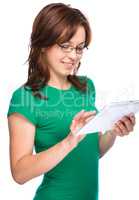 Young cheerful woman is using tablet