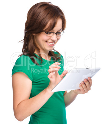 Young cheerful woman is using tablet