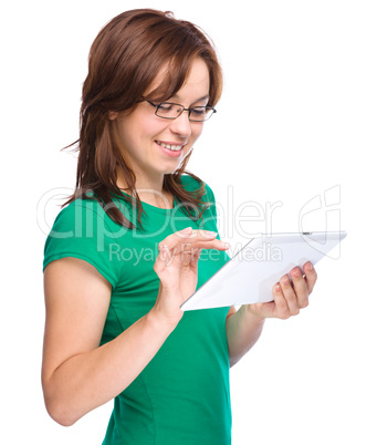 Young cheerful woman is using tablet