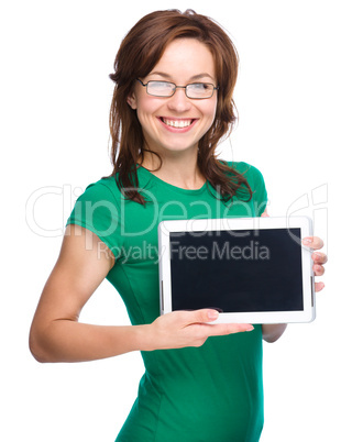 Young cheerful woman is showing blank tablet