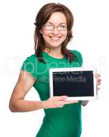 Young cheerful woman is showing blank tablet