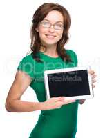 Young cheerful woman is showing blank tablet