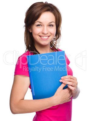 Young skinny student girl is holding exercise book