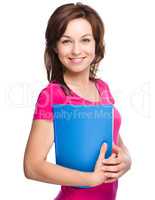 Young skinny student girl is holding exercise book